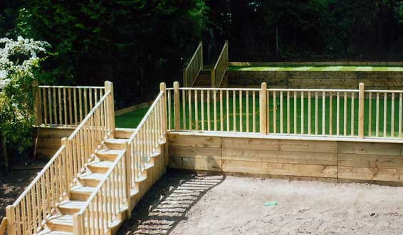 Wooden steps and handrail leading turfed lawn with balustrades